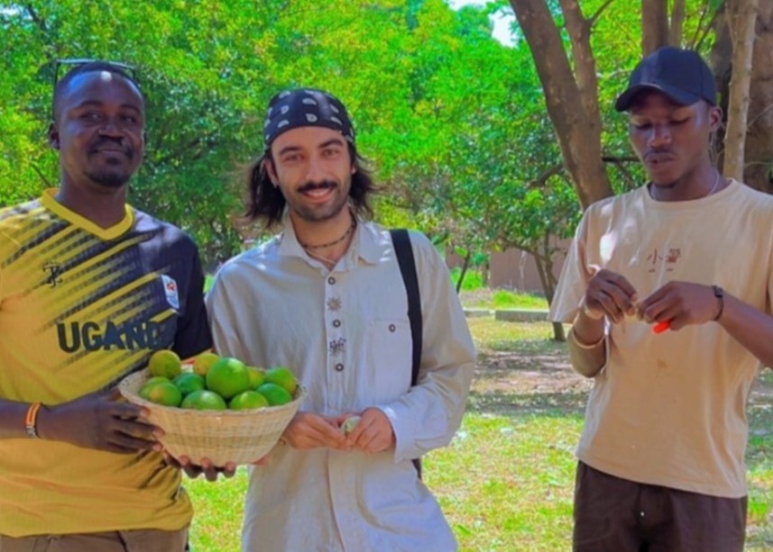 Happy tourists with a basket of fresh fruits in Bigodi wetland in Kibale forest, Uganda