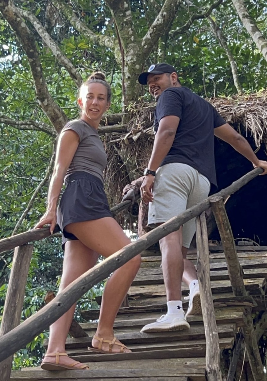 A tourist couple climbing on a Batwa tree house in Bwindi forest national park Uganda